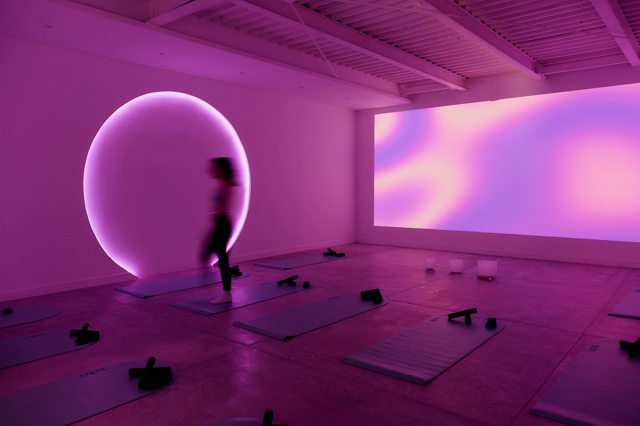 Silueta de mujer en movimiento con iluminación magenta en AAURA